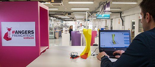 un homme regarde un écran d'ordinateur dans un atelier technologique